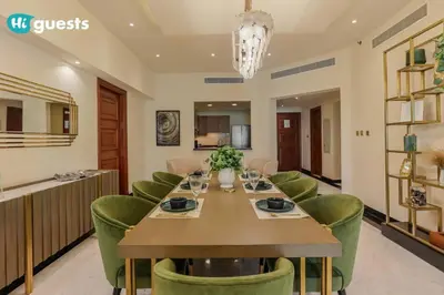 a dining room with a long table and green chairs at Higuests - Luxurious 2BR Haven in Iconic Palm Jumeirah in Dubai