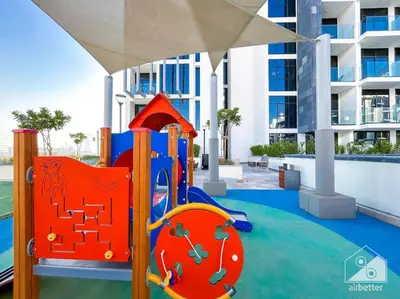 a playground in front of a apartment building at Luxury Living in Azizi Riviera & Cozy Balcony in Dubai