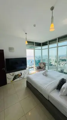 a bedroom with a large bed and a large window at Elegant 2BR Apartment in the Heart of Marina in Dubai