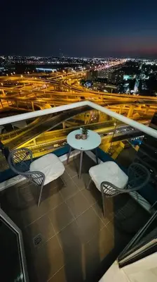 a balcony with a table and chairs and a city at Elegant 2BR Apartment in the Heart of Marina in Dubai