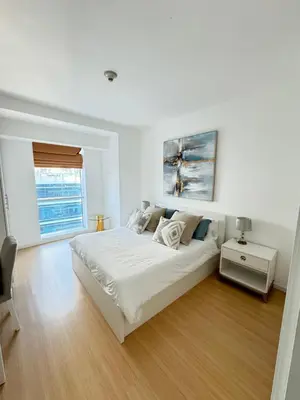 a white bedroom with a large bed and a window at Bel appartement Dubai marina in Dubai