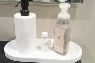 a bottle of soap and a soap dispenser on a sink at Bel appartement Dubai marina in Dubai