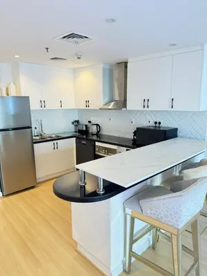 a kitchen with white cabinets and a white counter top at Bel appartement Dubai marina in Dubai