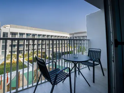 a patio with a table and chairs on a balcony at EasyGo - Modern STU- Luma22- JVC in Dubai