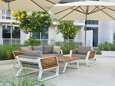 a patio with a couch and chairs and umbrellas at EasyGo - Modern STU- Luma22- JVC in Dubai