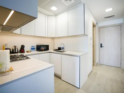 a white kitchen with white cabinets and a sink at EasyGo - Modern STU- Luma22- JVC in Dubai