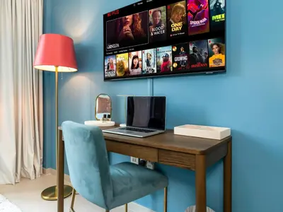 a desk with a laptop and a lamp and a tv at Premium 1 BDR, In Burj Khalifa Park, Dubai Mall Walking Distance , Opera House 1mn away in Dubai