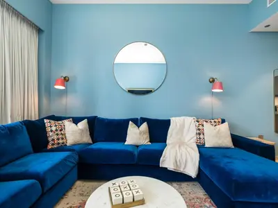 a blue living room with a blue couch and a mirror at Premium 1 BDR, In Burj Khalifa Park, Dubai Mall Walking Distance , Opera House 1mn away in Dubai