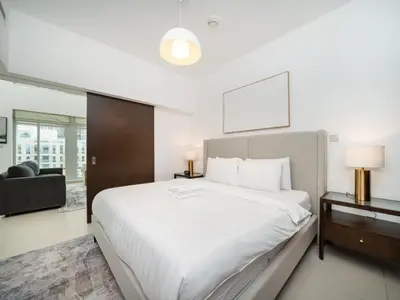 a bedroom with a large white bed and a chair at Elegant 2 Bed Downtown Duplex - Prime Location in Dubai