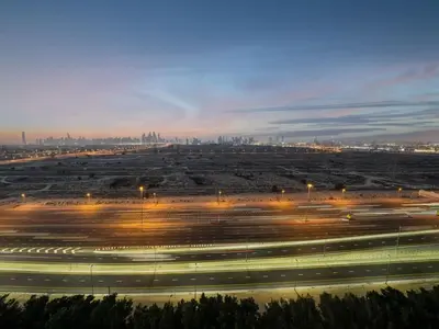 a large parking lot with a city in the background at Bright JVC Studio - Serenity Escape in Dubai