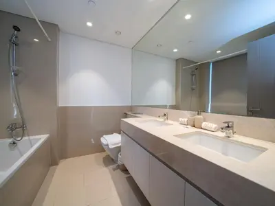 a bathroom with two sinks and a toilet and a mirror at Luxury Downtown 3 Bed with Full Burj Khalifa Views in Dubai