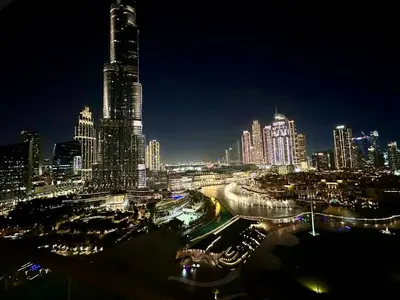 a night view of a city with tall buildings at New 2 Bedroom apartment overlooking Burj Khalifa and fountain view in downtown in Dubai