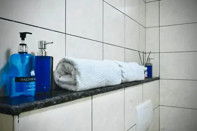 a bathroom with two bottles of soap and towels on a shelf at Marina Breeze Residence Near to Yachts and Beach in Dubai
