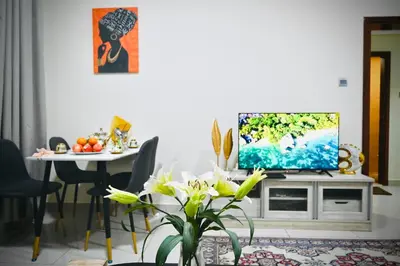 a living room with a television on a cabinet with a table at Marina Breeze Residence Near to Yachts and Beach in Dubai