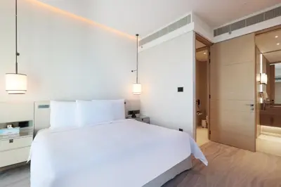 a bedroom with a white bed and a walk in shower at Stunning 1BR with Marina View And Beach Access in Dubai