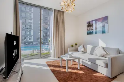 a living room with a couch and a tv at STAY BY LATINEM Luxury 1BR Holiday Home CV B207 near Burj Khalifa in Dubai