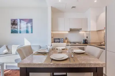 a kitchen and dining room with a table and chairs at STAY BY LATINEM Luxury 1BR Holiday Home CV B207 near Burj Khalifa in Dubai