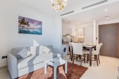 a living room and dining room with a couch and a table at STAY BY LATINEM Luxury 1BR Holiday Home CV B207 near Burj Khalifa in Dubai