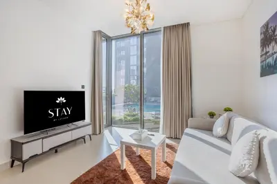 a living room with a white couch and a tv at STAY BY LATINEM Luxury 1BR Holiday Home CV B207 near Burj Khalifa in Dubai