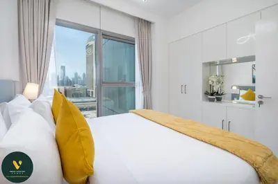 a bedroom with a white bed and a large window at Vogue Downtown Views II with Direct Access to Dubai Mall Via a Climate Controlled Bridge, Two Bedroom Apartment with Balcony and Burj Khalifa View in Dubai