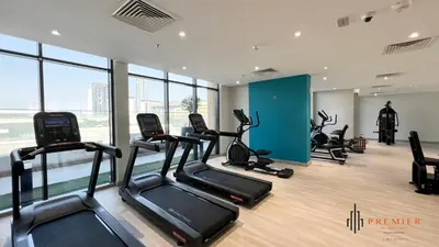 a gym with treadmills and ellipticals in a building at PREMIER 1BR - Burj Khalifa View in Dubai