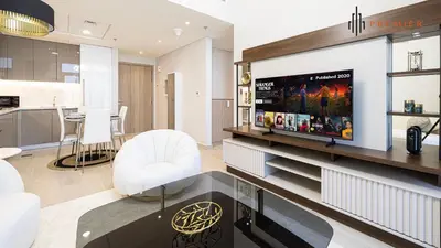 a living room with a flat screen tv on a entertainment center at PREMIER 1BR - Burj Khalifa View in Dubai
