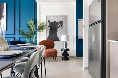 a dining room with blue walls and a table and chairs at Arthouse Grande Signature - 2 BR with Full Burj Khalifa and Fountain View in Dubai