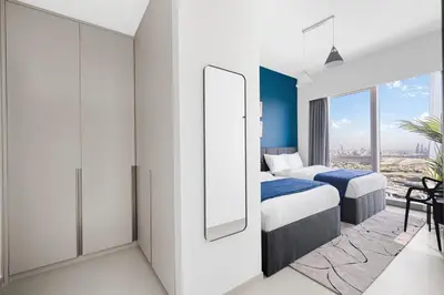 a hotel room with two beds and a mirror at Arthouse Grande Signature - 2 BR with Full Burj Khalifa and Fountain View in Dubai