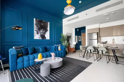 a living room with blue walls and a blue couch at Arthouse Grande Signature - 2 BR with Full Burj Khalifa and Fountain View in Dubai