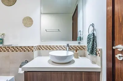 a bathroom with a white sink and a mirror at Elegant 2 Bedroom in Business Bay with Burj View in Dubai