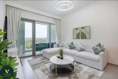 a living room with a white couch and a table at Vogue Downtown Views II with Direct Access to Dubai Mall Via a Climate Controlled Bridge, One Bedroom Apartment with Balcony and City View in Dubai