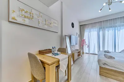 a bedroom with a desk and a bed and a desk and chairs at Chic Studio in Azizi Riviera with Modern Amenities in Dubai