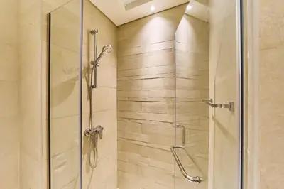 a shower with a glass door in a bathroom at Chic Studio in Azizi Riviera with Modern Amenities in Dubai