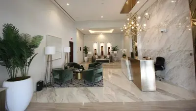 a lobby with a waiting area with green chairs and a lobby at Burj Khalifa View 1 Bedroom Apartment With Balcony For Up To 4 Person in Dubai