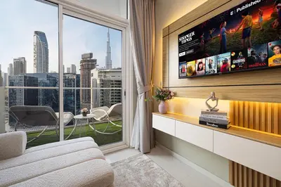 a living room with a tv and a large window at Burj Khalifa View 1 Bedroom Apartment With Balcony For Up To 4 Person in Dubai