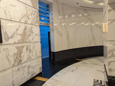 a hallway with white marble walls and a blue wall at Stunning 2BR Apartment with Full Marina View in Dubai