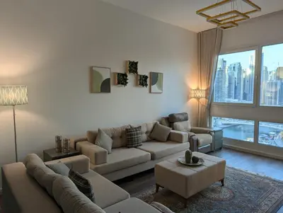 a living room with a couch and a large window at Stunning 2BR Apartment with Full Marina View in Dubai
