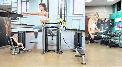 a woman in a gym with several people exercising on machines at Canal-View Duplex in Dubai