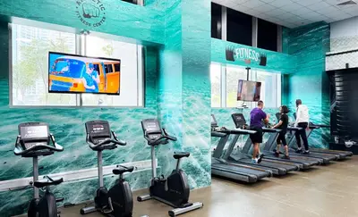 a gym with people on treadmills in a building at Canal-View Duplex in Dubai