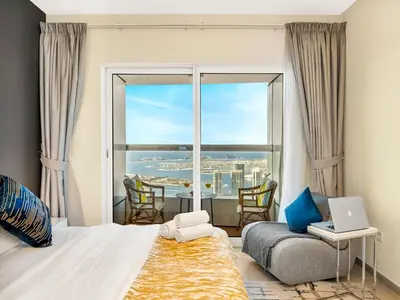 a bedroom with a bed and a large window at Iconic Palm & Sea Views on 58th Floor Skyline Apt in Dubai