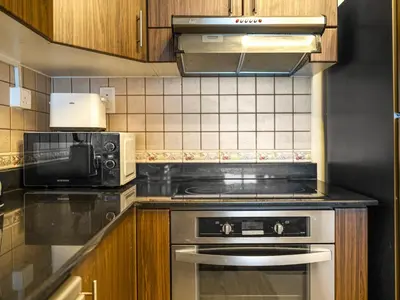 a kitchen with a stove and a microwave at Iconic Palm & Sea Views on 58th Floor Skyline Apt in Dubai