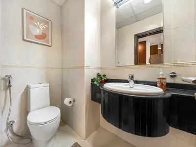 a bathroom with a toilet and a sink and a mirror at Iconic Palm & Sea Views on 58th Floor Skyline Apt in Dubai