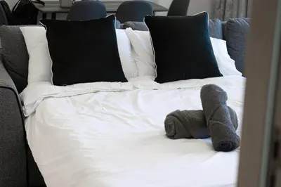 a stuffed teddy bear on a bed with pillows at Luxury 2BR Burj View & Jacuzzi in Dubai