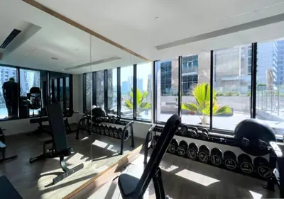 a gym with a lot of windows and tread machines at Luxury 2BR Burj View & Jacuzzi in Dubai