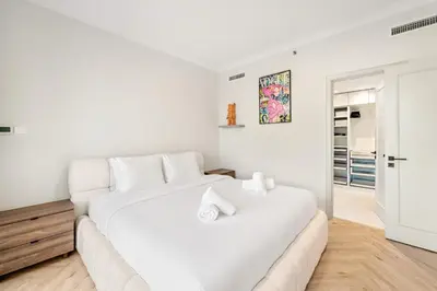 a white bedroom with a large white bed at Luxe 1BR in Fairways East with Canal Views in Dubai