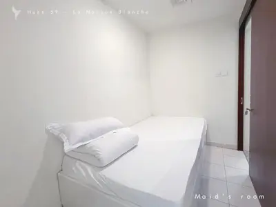a white room with a bed with white sheets at Huzz 59 - La Maison Blanche in Dubai