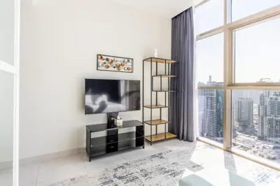 a living room with a tv and a large window at Exclusive Marina Stay - Posh 3BR with Stunning Views in Dubai