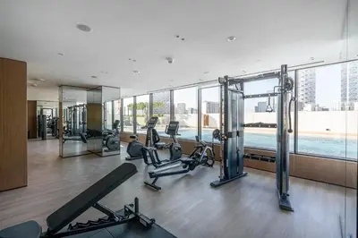 a gym with treadmills and exercise equipment in a building at Savis Home - Enjoy the City Skyline View 1BR in Binghatti Venus JVC in Dubai