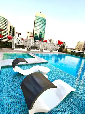 a pool with two umbrellas on top of a building at Chic 2BR near Dubai Mall & Burj l Canal & City view I 5 pax in Dubai
