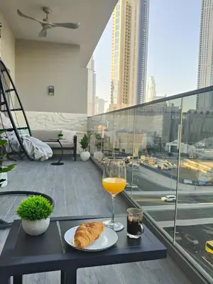 a table with a glass of orange juice and a plate of food at Chic 2BR near Dubai Mall & Burj l Canal & City view I 5 pax in Dubai